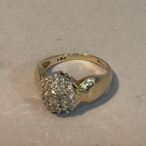 A diamond cluster ring in 9ct gold, the brilliant cut stones claw set within an oval outline,