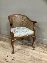 A 1920s/30s walnut and begere tub backed chair on cabriole legs with upholstered cushion