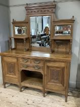 A late 19th century mid oak mirror back sideboard having a moulded cornice and carved with a