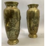 A pair of Japanese brass vases the bodies having moulded and etched decoration with flared rims,