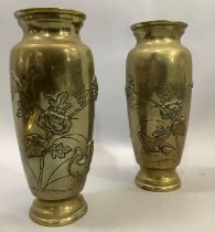 A pair of Japanese brass vases the bodies having moulded and etched decoration with flared rims,