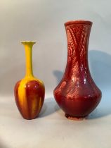 A Burmantoft's faience waisted vase with incised geometric design having a pink/red glaze