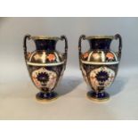 A pair of early 20th century Royal Crown Derby Imari pattern twin handled urns, 14cm high