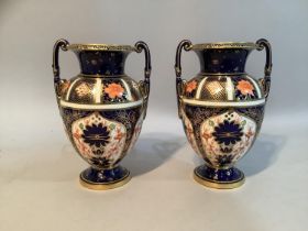 A pair of early 20th century Royal Crown Derby Imari pattern twin handled urns, 14cm high