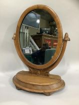 A Victorian mahogany toilet mirror having an oval plate, the base with hinged lid