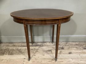 AN Edwardian and mahogany and rosewood cross banded occasional table of oval outline, ebony and