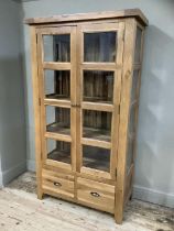 A good quality oak and glazed display cabinet having a pair of eight panelled doors and conforming