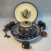 A Quimper ware plate, salt glazed pot and cover together with a dish, several carved animals and a