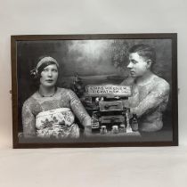 Three black and white framed photographic prints showing people being tattooed, 60cm x 90cm