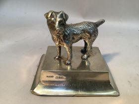 A silver model of Caesar, King Edward VII dog raised on a rectangular plinth, engraved to one