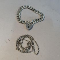A facetted curb link bracelet in silver with padlock fastener together with a silver belcher