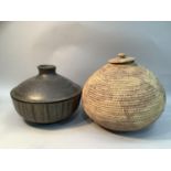 A stoneware pot and cover with dripped brown glaze together with an eastern woven basket with lid