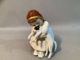 A Meissen porcelain figure after Konrad Hentschel of a girl sat on green box with a cat in her arms,