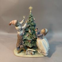 A Lladro figure group 'Trimming the Tree' 34cm high