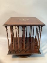 An Edwardian mahogany table top revolving book stand of square outline with slender ring turned