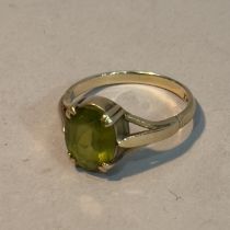 A dress ring c1965 claw set with an oval facetted peridot in yellow metal (tests as 9ct gold),