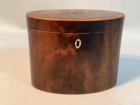 A George III figured mahogany tea caddy of oval outline with box wood stringing, bone escutcheon