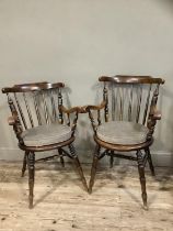 Two Victorian polished beech spindle back armchairs on turned legs, later cushion seats