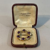 An amethyst and seed pearl wreath brooch in 9ct gold by Cropp and Farr Ltd c1956, claw set with