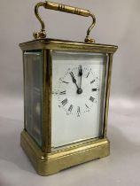 A brass French carriage clock having a white dial with Roman numerals and Arabic chapter ring,