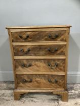 A reproduction mahogany chest of four graduated drawers with swing handles and on shaped bracket