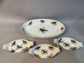A large Limoges serving dish painted with European birds together with three matching smaller dishes