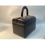 A 20th century black leather travel dressing case with fitted gold satin interior