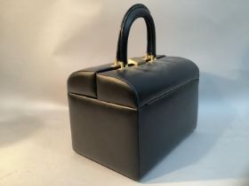 A 20th century black leather travel dressing case with fitted gold satin interior