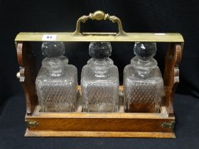 An Edwardian Oak Three Bottle Tantalus With Plated Mounts