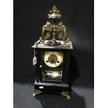 An Ebonized Mantel Clock With Circular Dial & Visible Movement, The Case Mounted With Cherubs