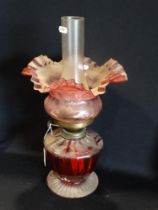 A Circular Based Cranberry Glass Oil Lamp With Cranberry Tinted Shade