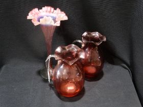 A Pair Of Cranberry Glass Handled Jugs, Together With A Pink Tinted Vase