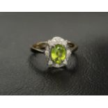 PERIDOT AND DIAMOND CLUSTER RING the central oval cut peridot measuring approximately 0.75cts,