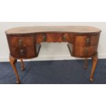 WALNUT KIDNEY SHAPED DRESSING TABLE with an arrangement of five drawers, standing on cabriole
