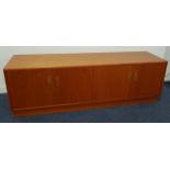 G PLAN TEAK SIDE CABINET with a moulded top above two pairs of cupboard doors, standing on a