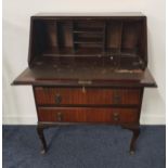 MAHOGANY BUREAU with a quarter veneered fall flap opening to reveal a fitted interior, above three