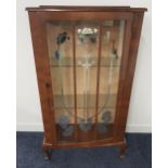 1950s WALNUT BOW FRONT DISPLAY CABINET with a raised back above a panelled glass door and glass