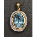 BLUE TOPAZ AND DIAMOND PENDANT the central bezel set oval cut blue topaz measuring approximately