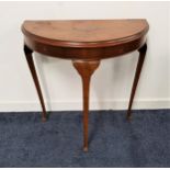 WALNUT SIDE TABLE with a D shaped moulded top, standing on three slender supports with pad feet,