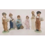 SIX NAO FIGURINES including a girl cuddling a puppy, 20cm high, two figurines of boys in dungarees