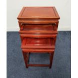 NEST OF CHINESE HARDWOOD TABLES with a shaped frieze standing on carved supports united by a