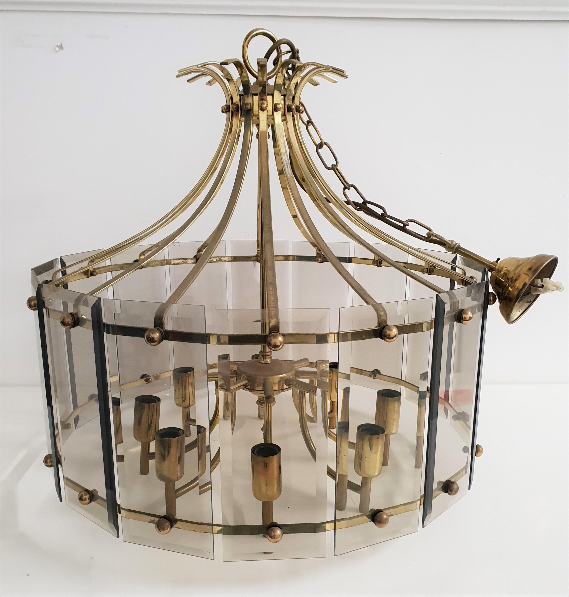 MODERN GILT BRASS CHANDELIER with smoked glass bevelled panels around eight shaped arms, with