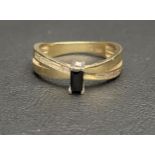 BLACK AND WHITE GEM SET DRESS RING in fourteen carat gold with crossover split shank, ring size T