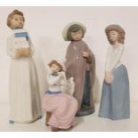 FOUR NAO FIGURINES including a child holding books, 28.5cm high, girl in a long skirt and hat,