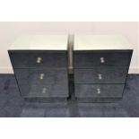 PAIR OF MIRRORED BEDSIDE CHESTS with bevelled tops above three drawers, standing on a plinth base,