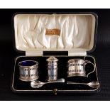 GEORGE V SILVER CRUET SET comprising a salt, pepper and lidded mustard pot all with blue glass