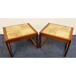 PAIR OF STAINED TEAK OCCASIONAL TABLES with inset tiled tops, standing on continuous loop
