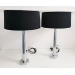 PAIR OF TABLE LAMPS raised on a circular chrome base with tapering chrome columns with black shades,