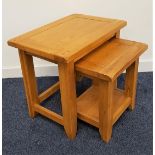 NEST OF LIGHT OAK TABLES with rectangular tops standing on shaped supports, 50cm high