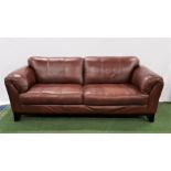 LARGE BROWN LEATHER SOFA with rollover arms, standing on stout shaped supports, 220cm long